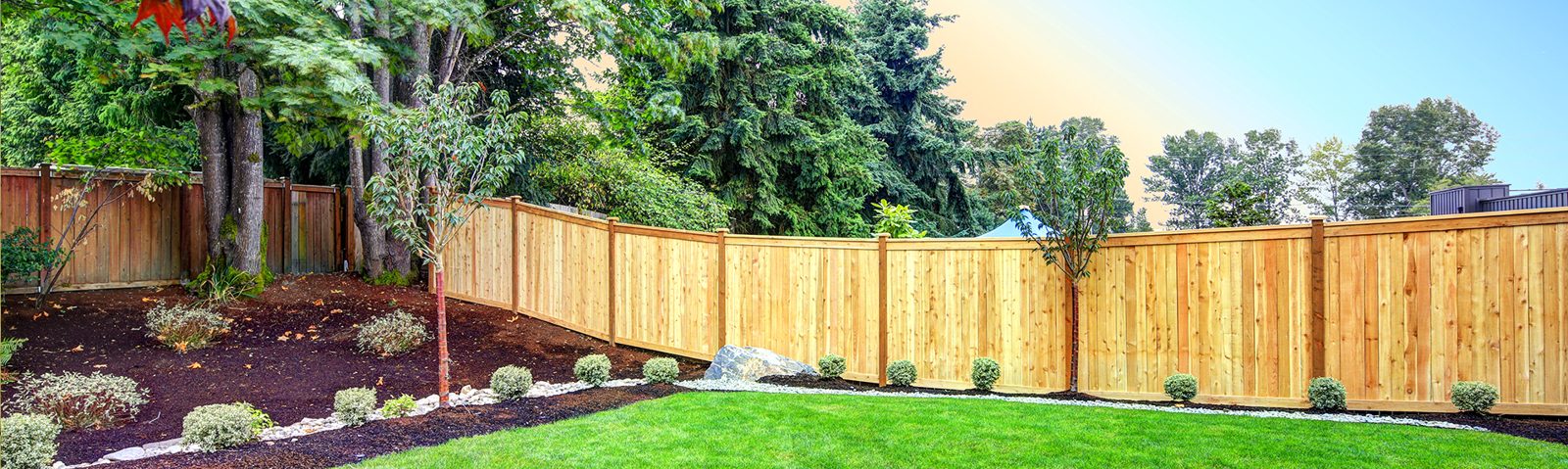 Long cedar privacy fence along a landscaped yard