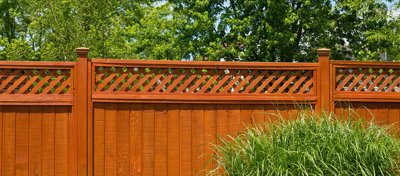 Stained wood privacy fence with lattice top